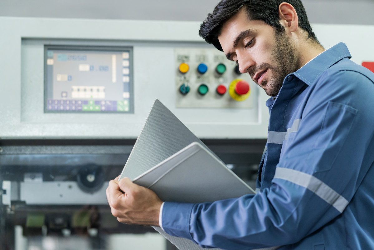 Male caucasian professional engineer examine checking machinery system progress of work flow and result of project in factory background industrial and technology concept